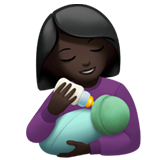 woman feeding baby: dark skin tone